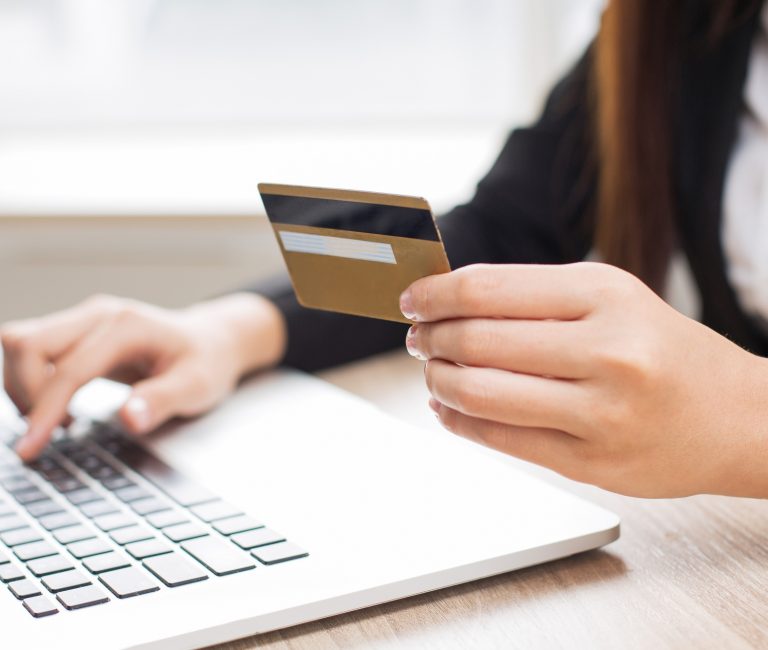entering credit card number on laptop for e-commerce